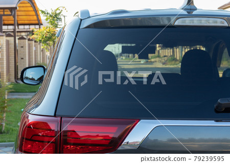 Car parked on the street in residential district, back view. Mock up of rear window for sticker or Car parked on the street in residential district, back view. Mock up of rear window for sticker or 79239595