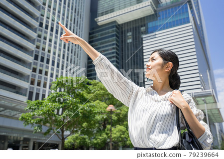 Business woman pointing in front of Nagoya station 79239664