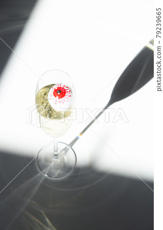 Red eye in a champagne glass in sunlight. Elegant Halloween decor. Autumn holiday concept. Top view, flat lay 79239665