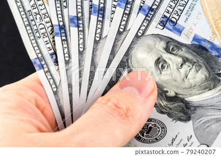 Hand holds 6 new one hundred dollar bills close-up 79240207