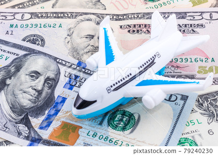 Close-up white plane toy on dollar bill background. Concept of traveling Close-up white plane toy on dollar bill background. Concept of traveling 79240230