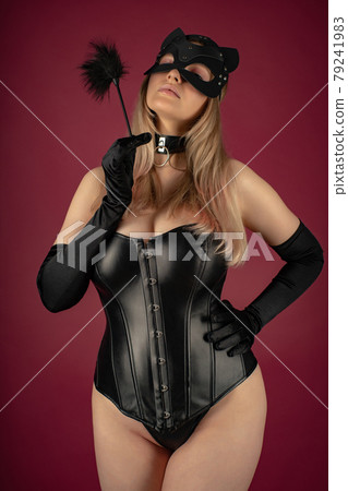 Beautiful young woman in a leather corset and cat mask Beautiful young woman in a leather corset and cat mask 79241983