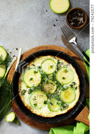 Breakfast. Summer omelet with zucchini and herbs on a stone or slate table. Top view flat lay. Copy space. 79242077
