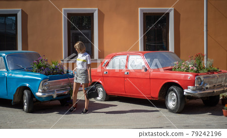 a young woman poses at an abandoned car with a flower garden in place of the engine a young woman poses at an abandoned car with a flower garden in place of the engine 79242196