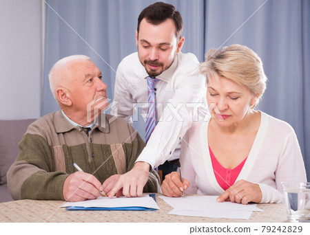 Woman and eldery man signing agreement 79242829