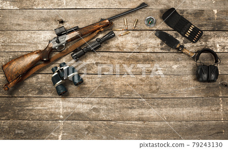 Hunting equipment on old wooden background including rifle, knife, binoculars and cartridges Hunting equipment on old wooden background including rifle, knife, binoculars and cartridges 79243130