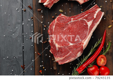 Raw rib eye steak on brown wooden board Raw rib eye steak on brown wooden board 79243135