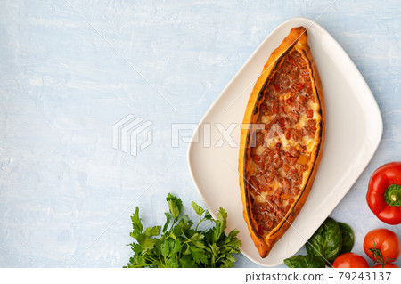 Turkish baked Pide bread on light blue wooden surface Turkish baked Pide bread on light blue wooden surface 79243137