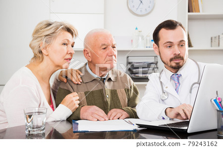 Old father with daughter visit doctor 79243162