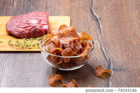 Selective focus on jerky in a glass bowl on a wooden background. Selective focus on jerky in a glass bowl on a wooden background. 79243186
