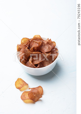 Cured meat in a white bowl, several meat chips on the background, vertical arrangement. Cured meat in a white bowl, several meat chips on the background, vertical arrangement. 79243196