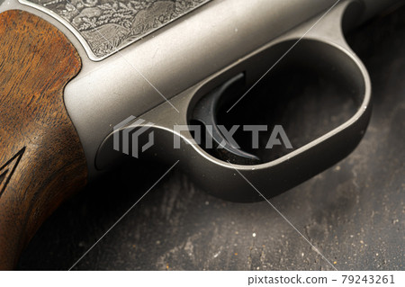 Metal trigger on hunting gun on black background Metal trigger on hunting gun on black background 79243261