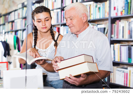 Nice old man with girl are reading books 79243602