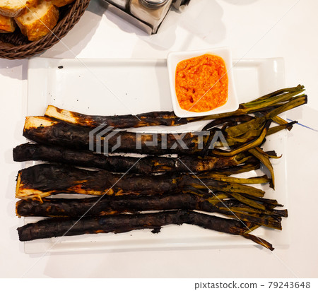 Calcots onions served on plate with Romesco sauce - traditional Catalan dish Calcots onions served on plate with Romesco sauce - traditional Catalan dish 79243648