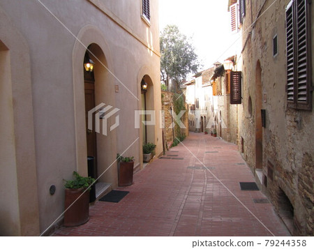 Italy / San Gimignano Back alley with soft tones in the afternoon sun 79244358