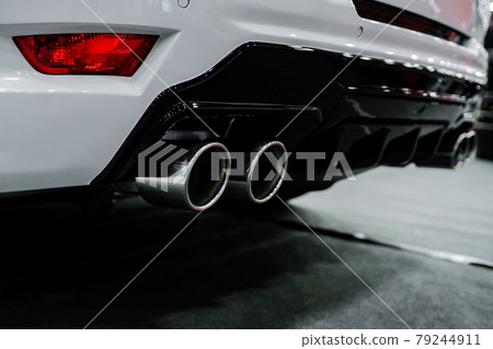 Close up of tuning white car exhaust pipe. Close up of tuning white car exhaust pipe. 79244911