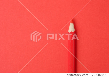 Red pencil on red paper background. Close up. 79246356