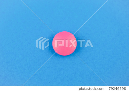 Pink pill on blue background. The concept of universal treatment. Panacea. Close up. 79246398