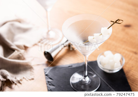 Gibson martini cocktail with onions on wooden table 79247475