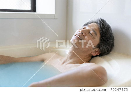 A man in his 50s relaxing in the bath A man in his 50s relaxing in the bath 79247573