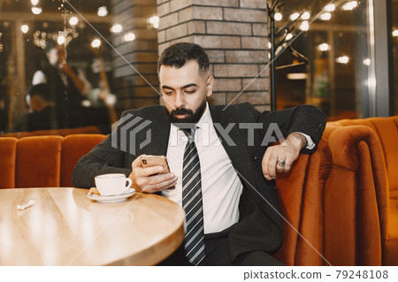 Stylish businessman with coffee sitting at the table Stylish businessman with coffee sitting at the table 79248108
