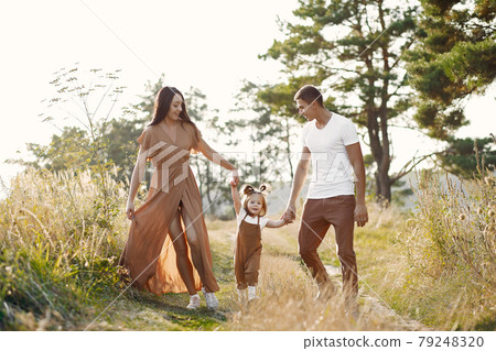 Cute family playing in a autumn field Cute family playing in a autumn field 79248320