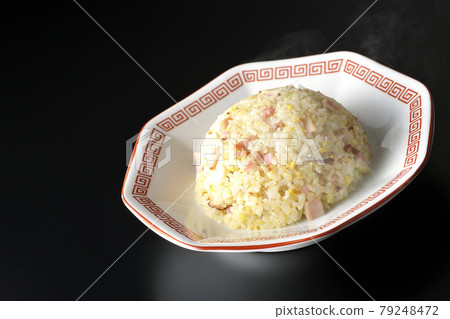 A hot five-eyed fried rice with various ingredients such as Narutomaki and char siu taken on a black background A hot five-eyed fried rice with various ingredients such as Narutomaki and char siu taken on a black background 79248472