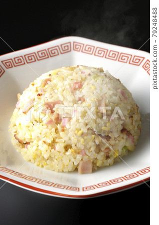 A hot five-eyed fried rice with various ingredients such as Narutomaki and char siu taken on a black background A hot five-eyed fried rice with various ingredients such as Narutomaki and char siu taken on a black background 79248488