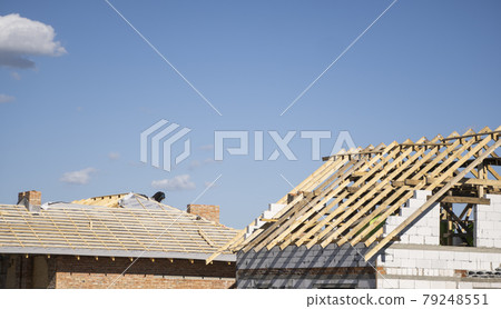 Wooden roof construction against blue sky. House building. 79248551