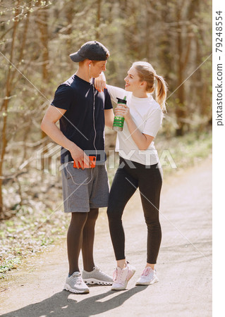 Sports couple training in a summer forest 79248554