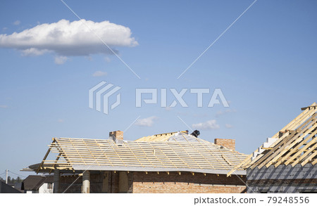 Wooden roof construction against blue sky. House building. 79248556