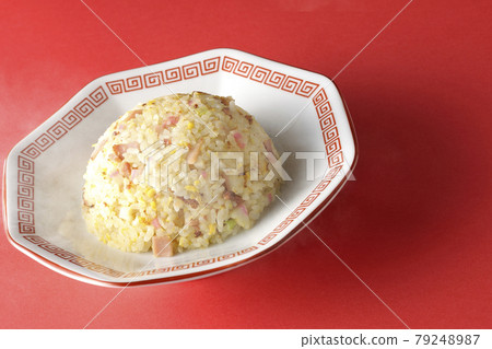 Photographed hot five-eyed fried rice with various ingredients such as Narutomaki and char siu on a red background Photographed hot five-eyed fried rice with various ingredients such as Narutomaki and char siu on a red background 79248987