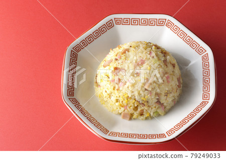 A bird's-eye view of hot five-eyed fried rice with various ingredients such as Narutomaki and char siu on a red background 79249033
