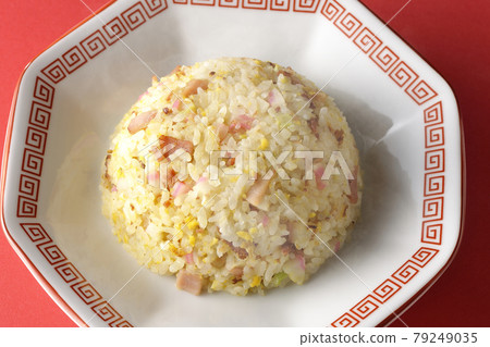 A bird's-eye view of hot five-eyed fried rice with various ingredients such as Narutomaki and char siu on a red background 79249035