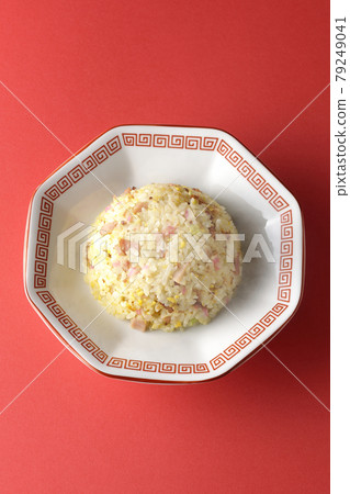 A bird's-eye view of hot five-eyed fried rice with various ingredients such as Narutomaki and char siu on a red background 79249041