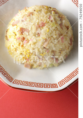 A bird's-eye view of hot five-eyed fried rice with various ingredients such as Narutomaki and char siu on a red background A bird's-eye view of hot five-eyed fried rice with various ingredients such as Narutomaki and char siu on a red background 79249050