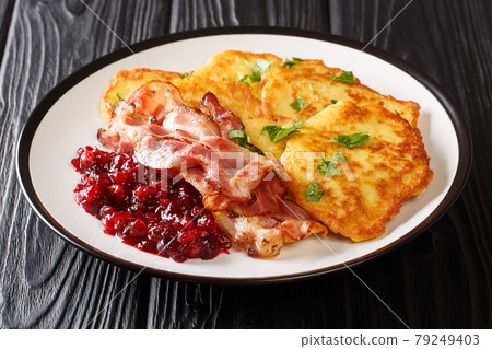 Raggmunk or rarakor is one of the most swedish dishes it pancakes mixed with shredded potatoes serve side pork with lingonberry jam close-up on the table. horizontal 79249403