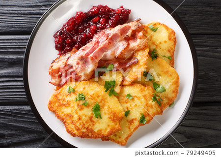 Scandinavian potato pancakes served with lingonberry jam and bacon close-up on a plate. horizontal top view 79249405