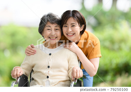 Senior women, young women, fresh green care, smiles, wheelchairs 79250100