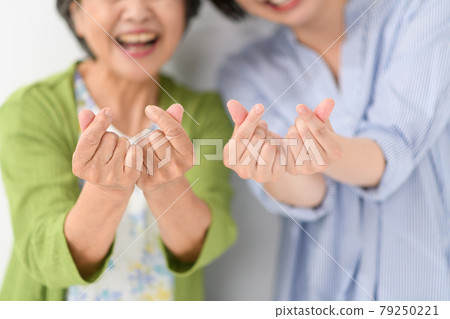 Senior woman young woman heart Senior woman young woman heart 79250221
