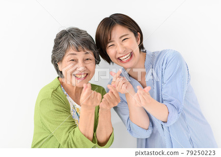Senior woman, young woman, smile, heart Senior woman, young woman, smile, heart 79250223