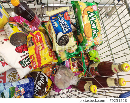 PENANG, MALAYSIA - MARCH 29, 2021: Groceries that have been picked up are placed in the cart before payment is made at the payment counter. Shopping carts make it easy for customers to shop. 79251228