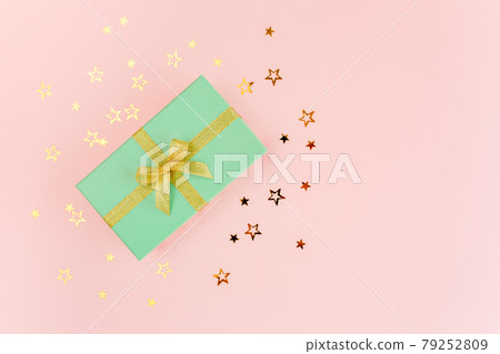 Gift or present box and stars confetti on a pink background. Colorful celebration, birthday. Christmas or New Year pattern. Flat lay, top view  79252809