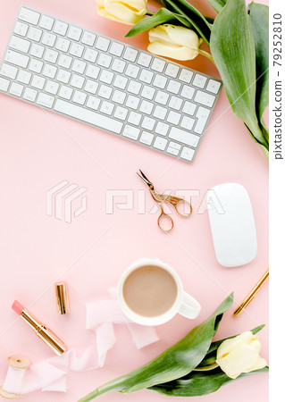 Female workspace with computer, tulip flowers bouquet, golden accessories, diary, on pink background. Flat lay women's office desk. Top view 79252810