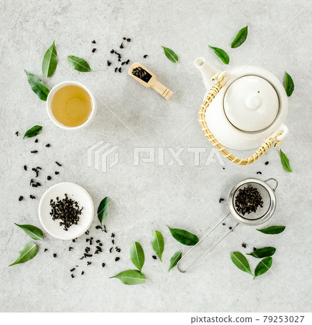 Herbal tea with two white tea cups and teapot, with green tea leaves. Flat lay, top view. Tea concept Herbal tea with two white tea cups and teapot, with green tea leaves. Flat lay, top view. Tea concept 79253027