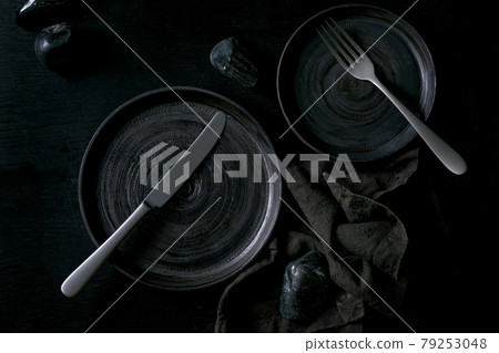 Empty black ceramic plates with black stones 79253048