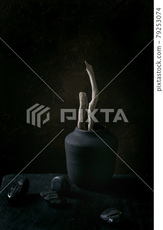 Black ceramic vase on black wooden table 79253074