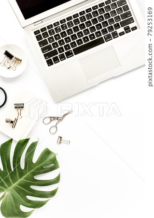 Home office workspace mockup with laptop, tropical leaves Monstera, clipboard, notebook and accessories on white background. Flat lay, top view 79253169