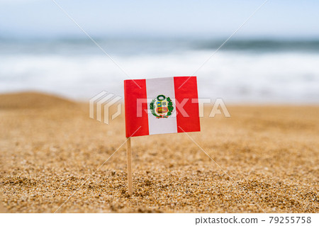 Flag of Peru in the form of a toothpick in the sand of beach opposite sea wave. Travel concept Flag of Peru in the form of a toothpick in the sand of beach opposite sea wave. Travel concept 79255758