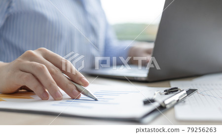 Asian business women are analyzing graphs, financial statistics and calculating corporate returns in private offices, Market research reports and income statistics, Financial and Accounting concept. Asian business women are analyzing graphs, financial statistics and calculating corporate returns in private offices, Market research reports and income statistics, Financial and Accounting concept. 79256263